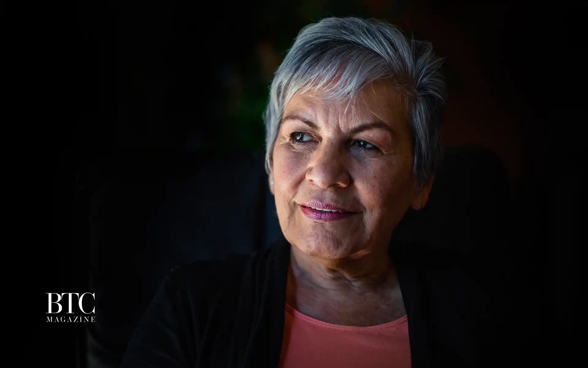 Elderly woman holding published book smiling