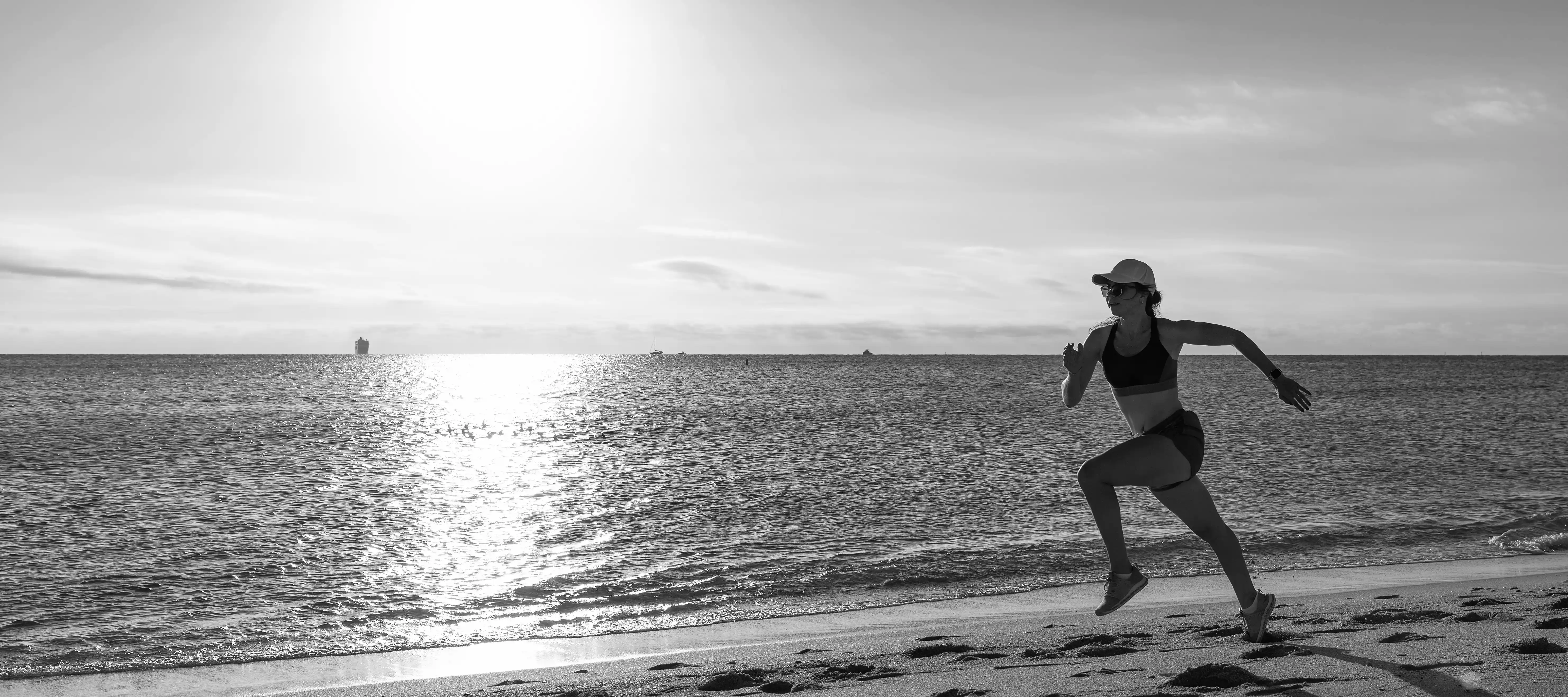 Health and wellness athletic woman running on beach sunrise